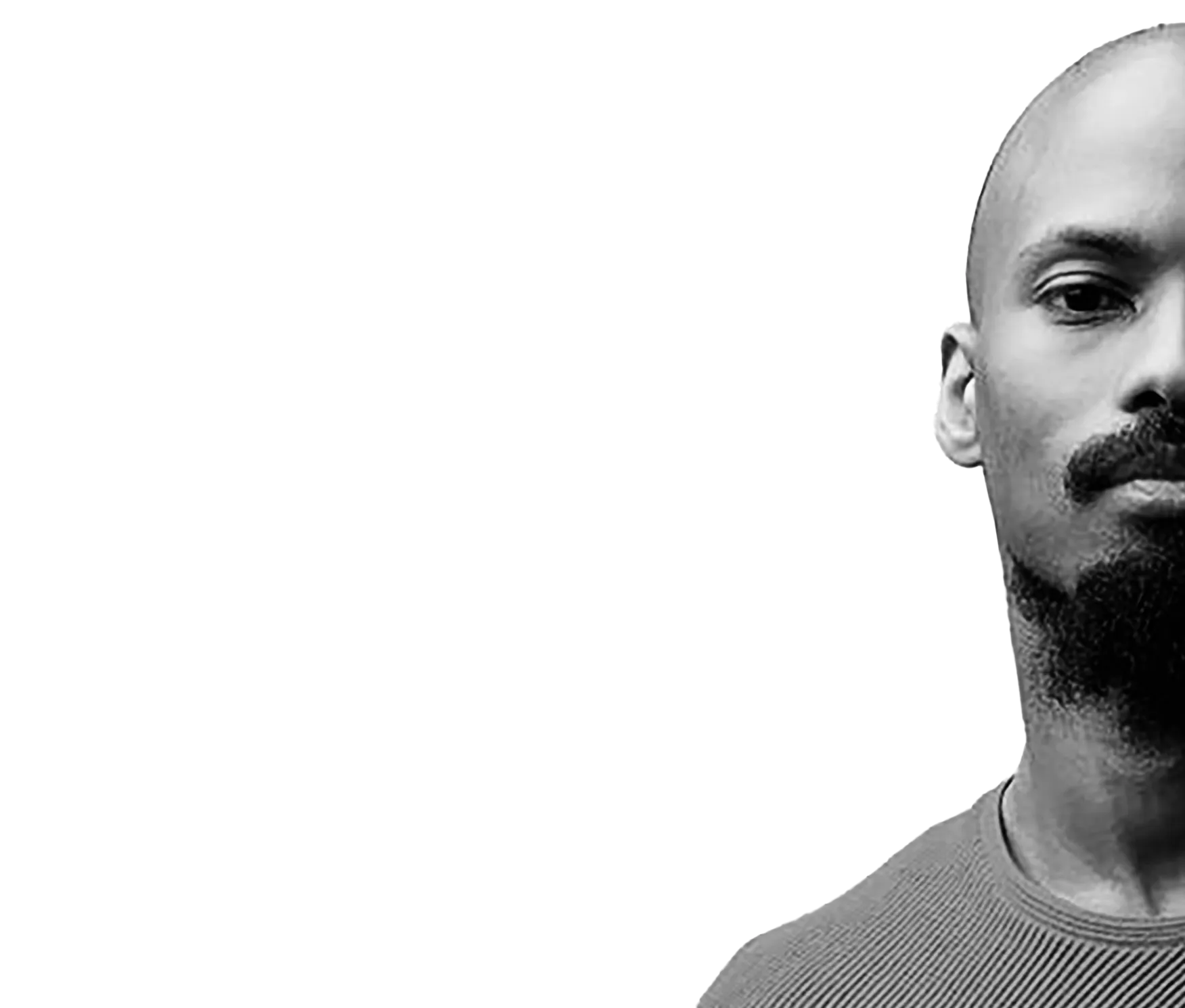 Portrait en noir et blanc d’Alex Ribeiro, le visage en partie cadré, regard direct.